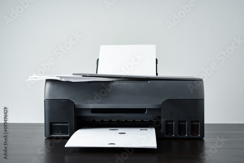 Printer with paper on gray background close up