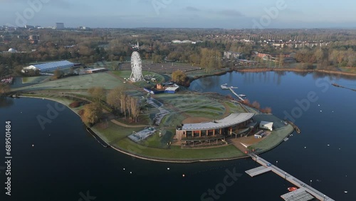 An aerial, early morning view of Willen Lake in Milton Keynes, showing the waterfront and Observation Wheel. Tracking left to right while circling the waterfront over the lake. photo