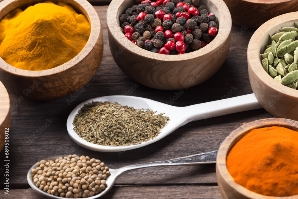 Spices and herbs in wooden bowls and spoons. Food and cooking ingredients. Spices and herbs in wooden bowls and spoons. Food and cooking ingredients.