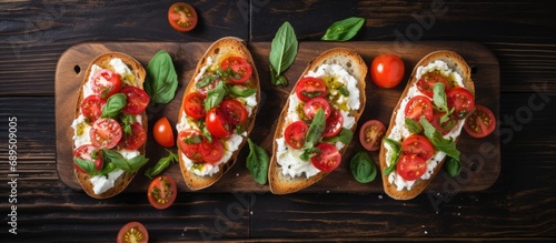 Italian bruschetta with ricotta cheese, lettuce, cherry tomatoes. Table top view, empty space. photo