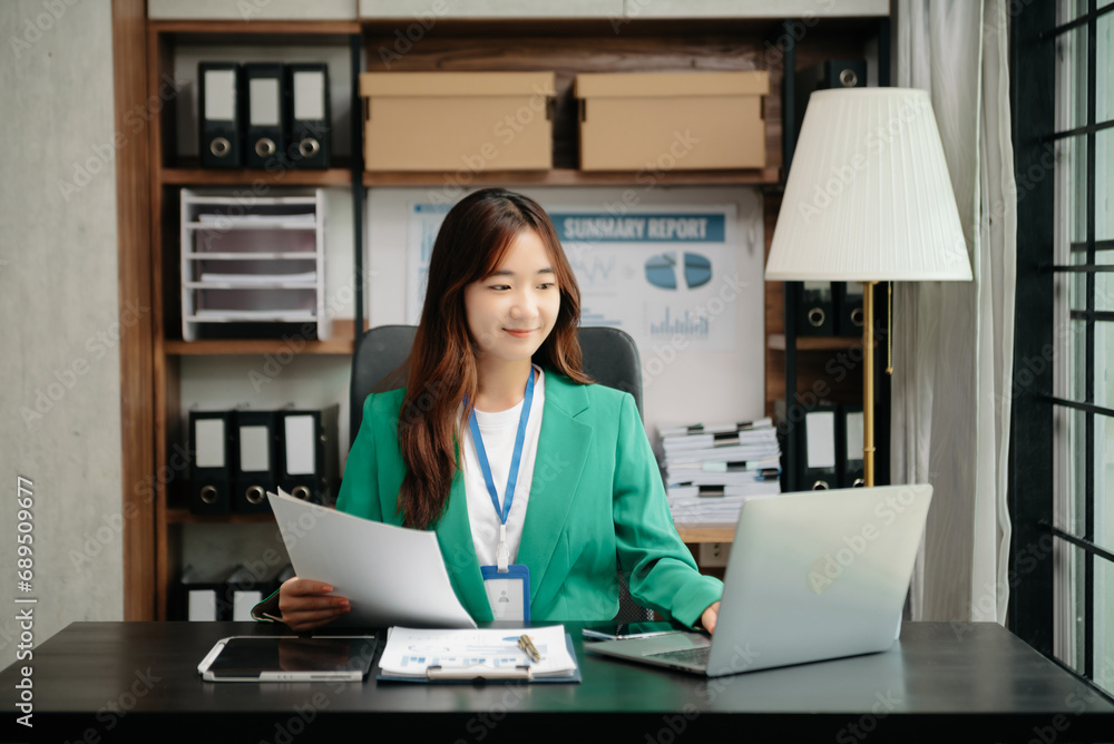 Young beautiful woman using laptop and tablet while sitting at her working place. Concentrated at work.. Young beautiful woman using laptop and tablet while sitting at her working place. Concentrated at work..