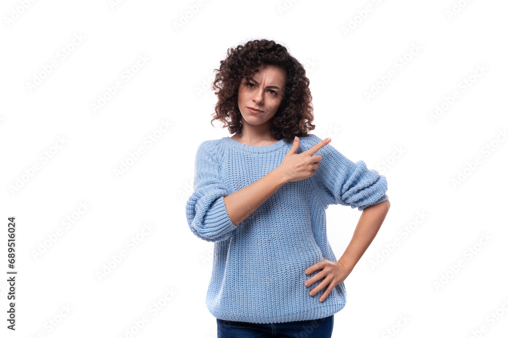 doubtful young curly brunette woman dressed in a blue sweater look suspiciously at the camera doubtful young curly brunette woman dressed in a blue sweater look suspiciously at the camera