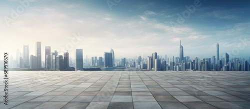 Empty concrete square floor surrounded by buildings and a panoramic skyline.