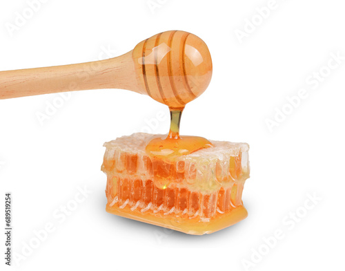 Sweet honeycomb and wooden dipper with dripping honey isolated on transparent