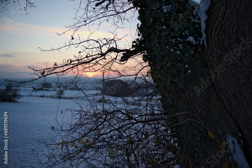 Stimmungsvoller Sonnenuntergang am kalten Winterabend nach dem ersten Schnee