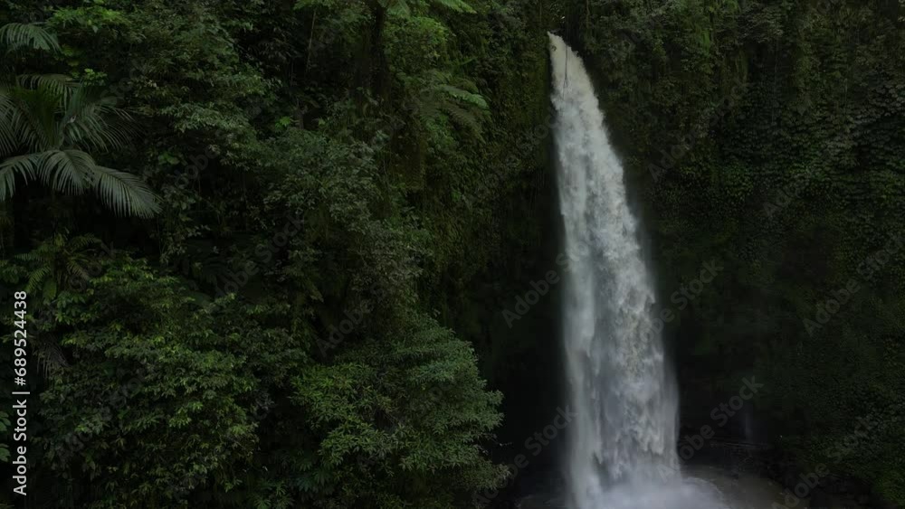 Jungle environment with a slow reveal of a powerful waterfall in Bali, Indonesia. Aerial. Jungle environment with a slow reveal of a powerful waterfall in Bali, Indonesia. Aerial.