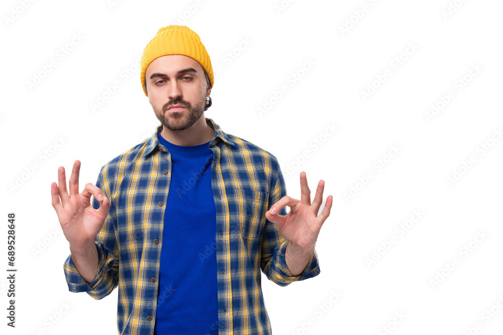 young stylish brunette man with a beard and mustache in a shirt and hat thinks holding his head young stylish brunette man with a beard and mustache in a shirt and hat thinks holding his head