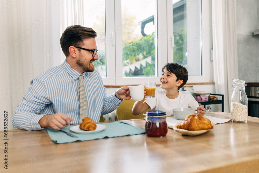 Working dad is having breakfast with his son. Working dad is having breakfast with his son.