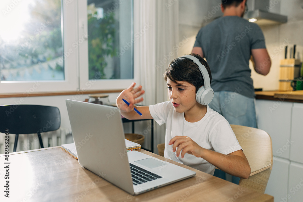 Young Caucasian boy waving in the online class. Young Caucasian boy waving in the online class.
