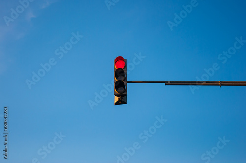 Traffic light showing red with blue sky background