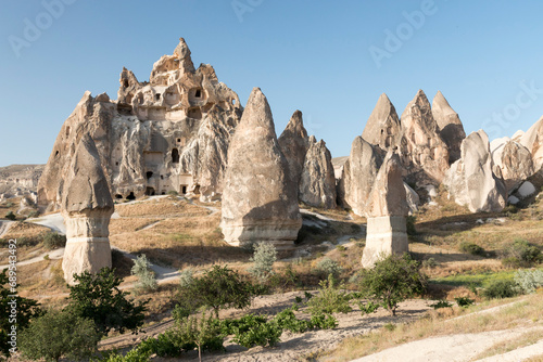 fairy chimneys and volcanic cliffs with carved dove houses in the background in Rose Valley, Cappadocia, Turkey