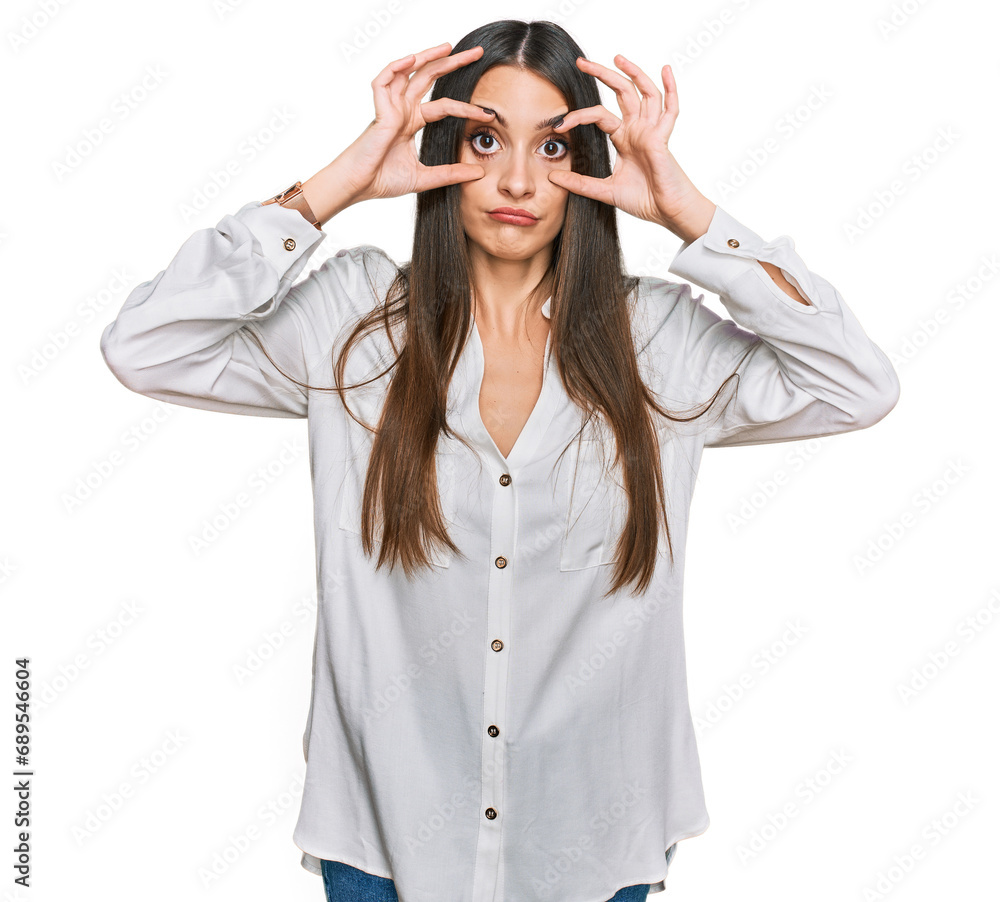 Young beautiful woman wearing casual white shirt trying to open eyes with fingers, sleepy and tired for morning fatigue Young beautiful woman wearing casual white shirt trying to open eyes with fingers, sleepy and tired for morning fatigue