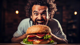 Man is eating the burger in restaurant