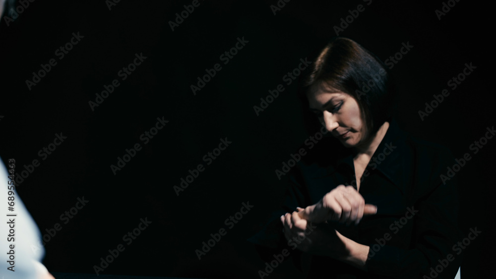 An arrested woman is rubbing her sore hands after handcuffs, a lack of evidence for the arrest An arrested woman is rubbing her sore hands after handcuffs, a lack of evidence for the arrest