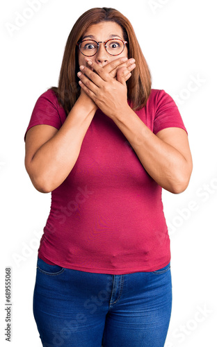 Middle age latin woman wearing casual clothes and glasses shocked covering mouth with hands for mistake. secret concept.
