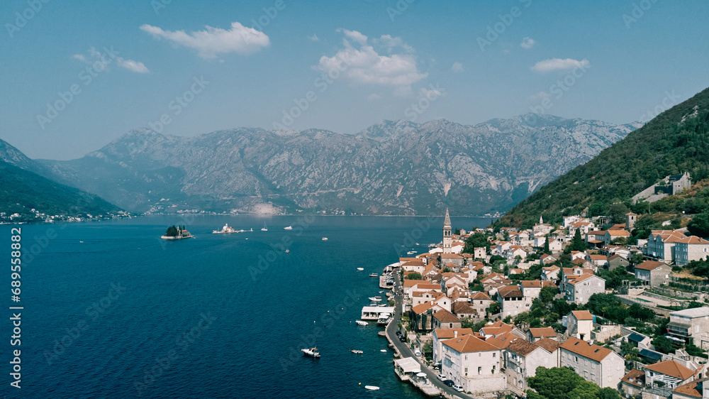 Boats sail along the Bay of Kotor past the coast of Perast. Montenegro. Drone