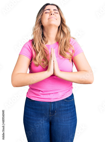 Young caucasian woman wearing sportswear begging and praying with hands together with hope expression on face very emotional and worried. begging.