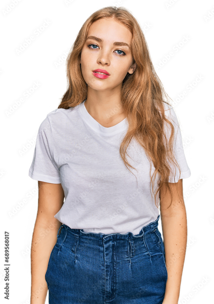 Fototapeta premium Young caucasian girl wearing casual white t shirt with serious expression on face. simple and natural looking at the camera.