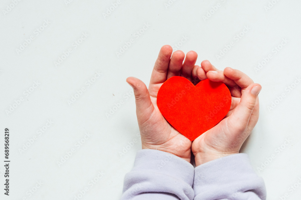 Fototapeta premium A red heart in a child's hand. High quality photo