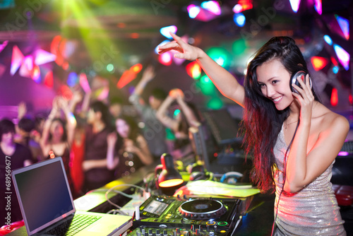 Chinese DJ doing record scratching in nightclub photo