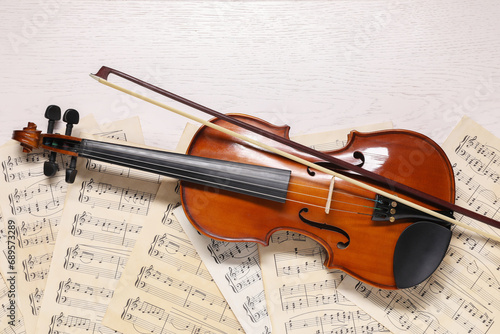 Canvas Print Violin, bow and music sheets on white wooden table, top view