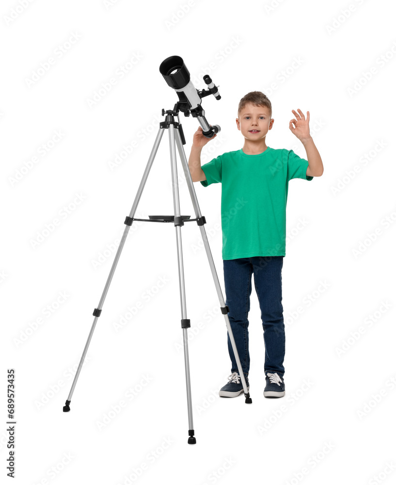 Cute little boy with telescope showing ok gesture on white background