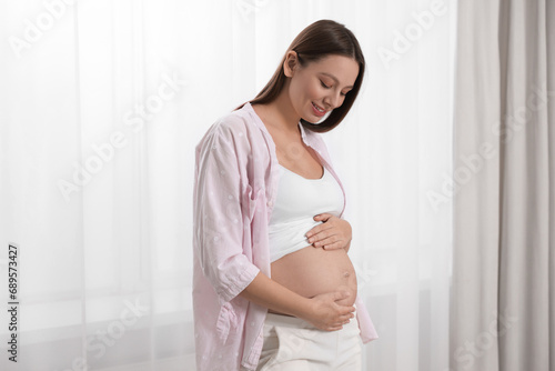Beautiful pregnant woman in pink shirt near window indoors Free Download Beautiful pregnant woman in pink shirt near window indoors - GFXLoad