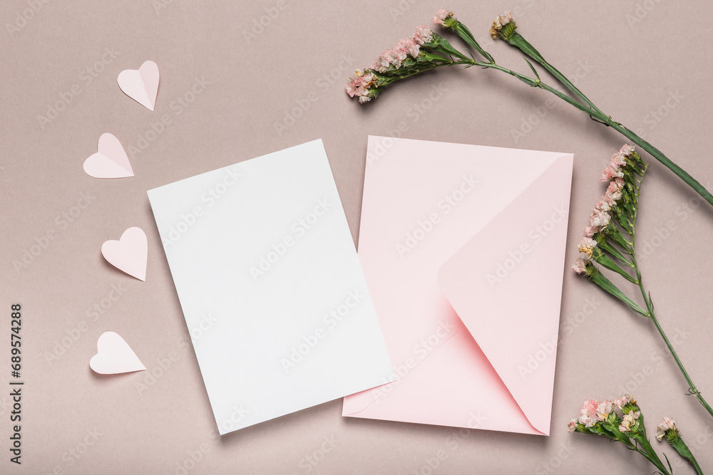 Pink envelope and blank form, pink flowers on a brown background. Paper pink hearts. Concept for Valentine's Day, Mother's Day. Pink envelope and blank form, pink flowers on a brown background. Paper pink hearts. Concept for Valentine's Day, Mother's Day.