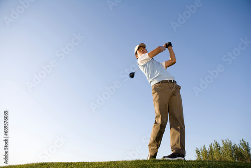 Golfer teeing off on the course photo
