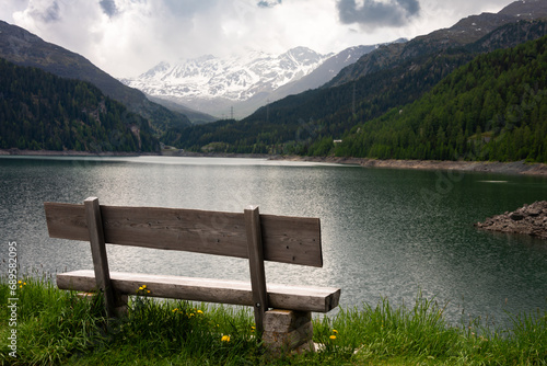 Wooden bench at mountain lake in Swiss alps