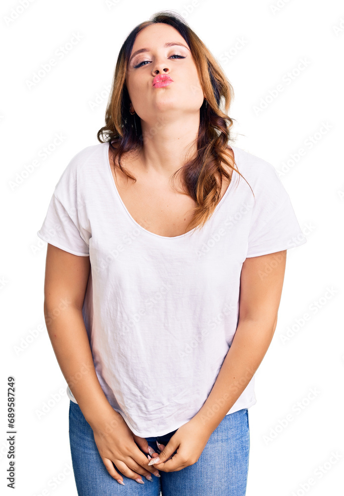 Young beautiful caucasian woman wearing casual white tshirt looking at the camera blowing a kiss on air being lovely and sexy. love expression. Young beautiful caucasian woman wearing casual white tshirt looking at the camera blowing a kiss on air being lovely and sexy. love expression.