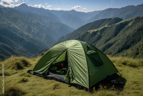 green tent in the middle of the grass in the mountains 