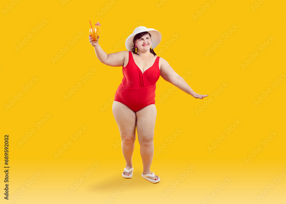 Happy fat woman having fun at beach party on summer holiday. Full length studio portrait of beautiful smiling young plump overweight lady in red swimsuit holding cocktail standing on yellow background Happy fat woman having fun at beach party on summer holiday. Full length studio portrait of beautiful smiling young plump overweight lady in red swimsuit holding cocktail standing on yellow background