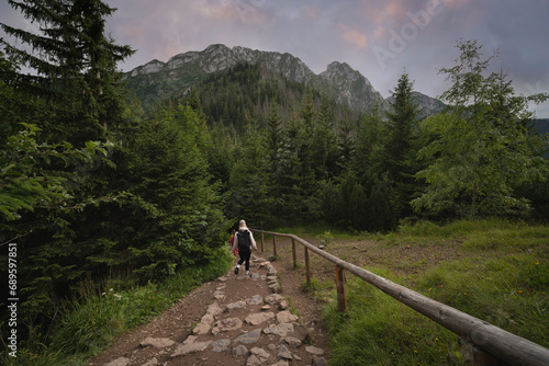 Travelers in the Polish Tatras in summer, view from the back.