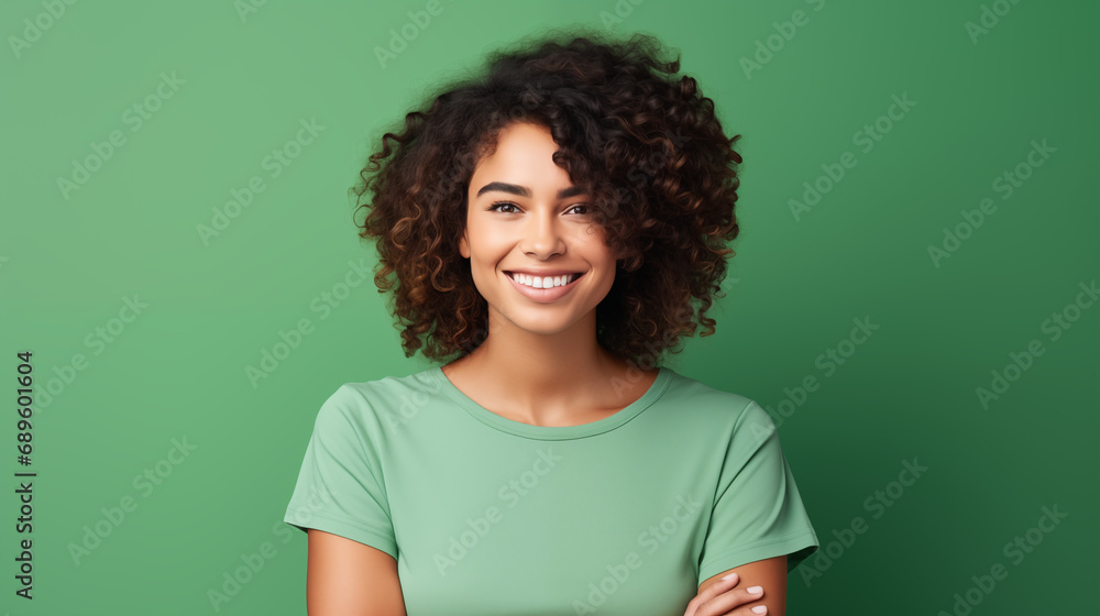 Beautiful black woman wearing a green t-shirt, smiling and looking at the camera on a plain green background Beautiful black woman wearing a green t-shirt, smiling and looking at the camera on a plain green background