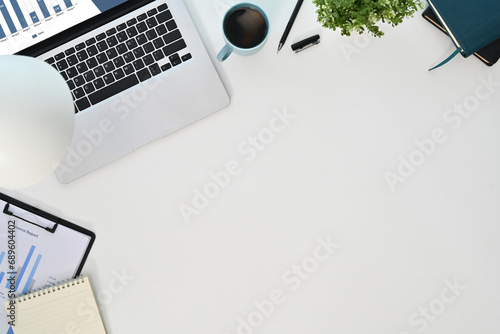 Top view laptop computer, coffee cup, document and coffee cup on white background photo