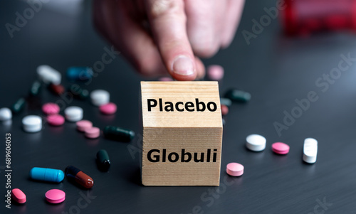 Symbol that homeopathic medicine has an placebo effect only. Hand turns cube and changes the German word 'Globulin' (globule) to 'placebo'..