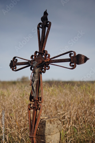 Stary krzyż stojący w polu, łące.