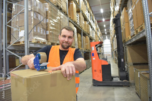 workers in a goods warehouse in the retail trade packaged a package with adhesive tape