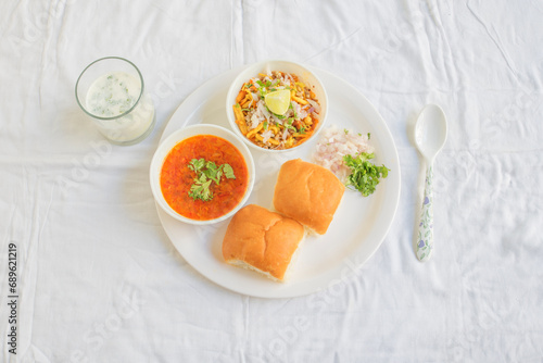 Misal Pav with buttermilk is a special dish in Maharashtra, India. for breakfast or as a midday snack, served over a white background