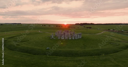 Drone flies around the iconic Stonehenge stones during breathtaking pink sunset