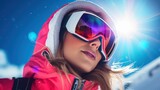 Portrait of smiling female skier with goggles on blue sky background on sunny winter day. Woman with ski goggles and colorful clothing. Fashion winter vacations concept.