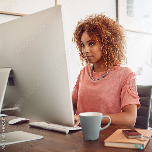 Businesswoman, typing or designer with computer for research, editing or copywriting on blog or web. Startup, agency or African woman in office working on internet update, networking or reading news photo