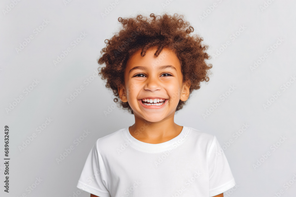 Cute mixed race boy child model with perfect clean teeth laughing and smiling, happy. Curly hair and white shirt, healthy. Isolated on white background. - obrazy, fototapety, plakaty 