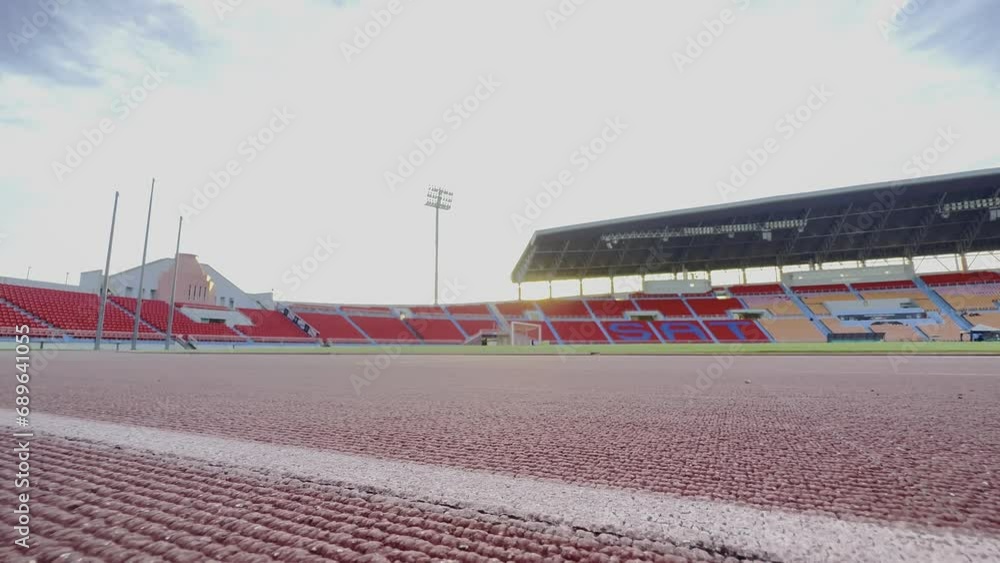 Asian para-athletes with prosthetic blades sprint on a running track at stadium. Asian para-athletes with prosthetic blades sprint on a running track at stadium.