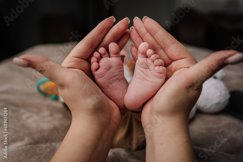 Parent holding in the hands feet of newborn baby. photo