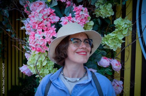 Portrait of a woman against a wall decorated with flowers