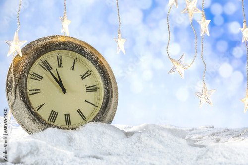 Big new year closk on table and free space for your products. Blurred background of landscape and snow flakes with frost. Mockup backdrop of december time at night. photo