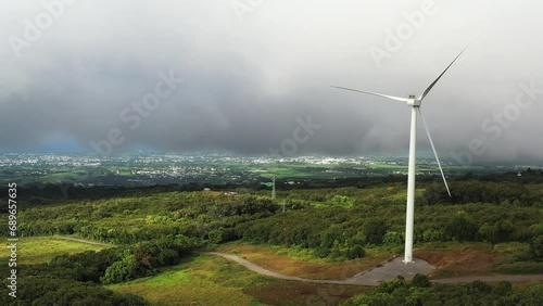 Aerial drone view of windmills, fields and rainforest with low hanging clouds, Sainte Suzanne, Reunion. photo