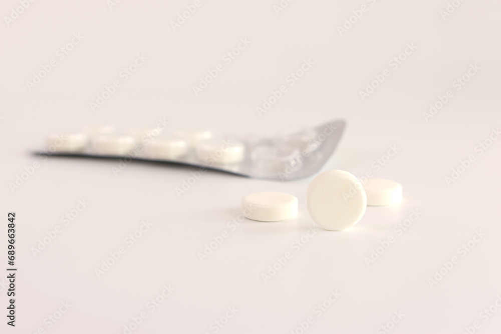 A pack of white pills on a white background. Medicine and health care. A pack of white pills on a white background. Medicine and health care.